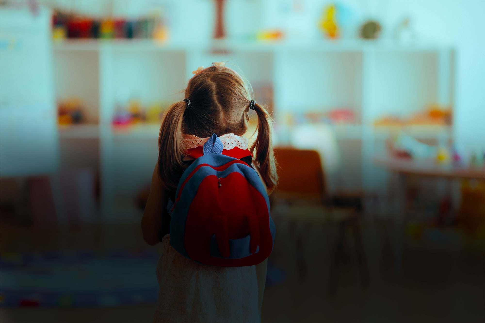 Jente med skolesekk i klasserom