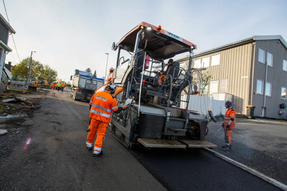 Arbeidere legger asfalt i R&oslash;stbakken.