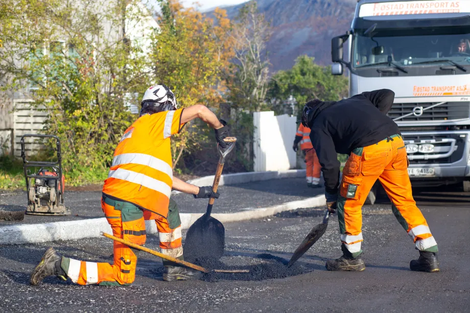 Arbeidere legger asfalt i R&oslash;stbakken.
