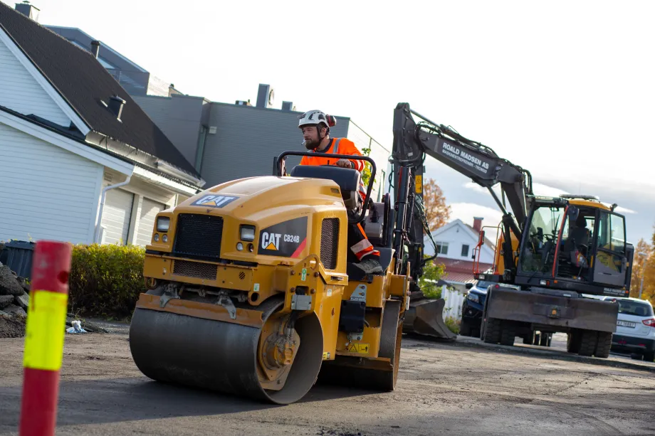Arbeidere legger asfalt i R&oslash;stbakken.