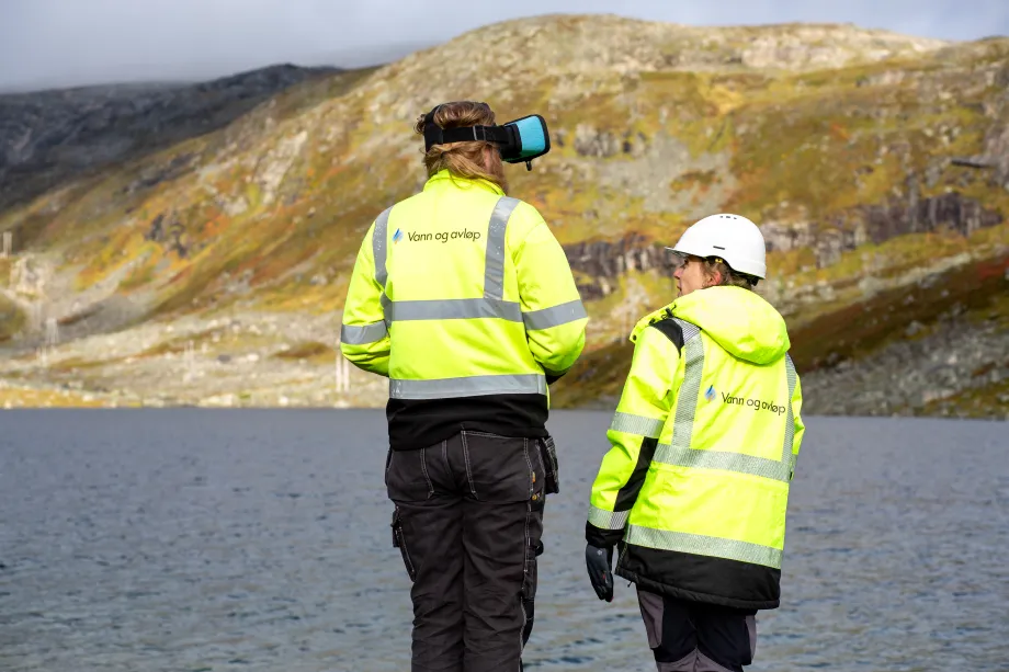 To arbeidere står ved drikkevannskilde.