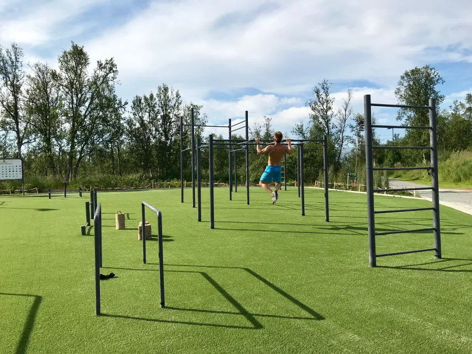 Mann gj&oslash;r pullups i treningsparken p&aring; Charlottenlund aktivitets- og friluftspark