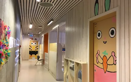 Kvamstykket barnehage inne Gang i Kvamstykket barnehage med fargerike tegninger på dørene