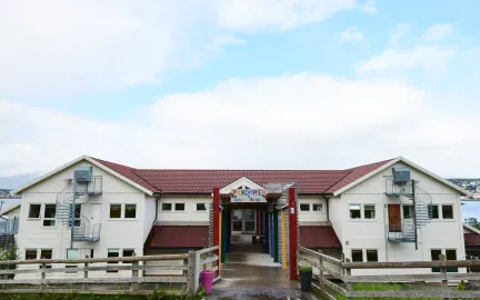 Reinen barnehage sett utenfra en sensommerdag med skyer og bl&aring; himmel