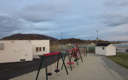 Sommarøy barnehage uteområde Sommarøy barnehage uteområde med husker og sandkasse en sommerdag