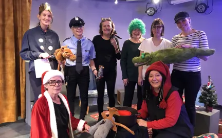 &Aring;tte personer i kostyme smiler mot kamera. Foto.