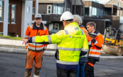 Arbeidere legger asfalt i R&oslash;stbakken.