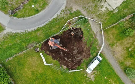 Dronebilde av gravemaskin og gr&oslash;ft i skoleg&aring;rd