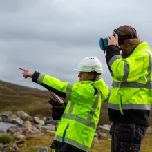 To arbeidere st&aring;r ved drikkevannskilde.