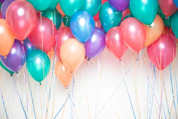 R&oslash;de, gr&oslash;nne, lilla og oransje ballonger mot hvit bakgrunn. Illustrasjonsfoto.