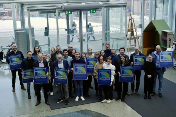 Milj&oslash;fyrt&aring;rnsertifiserte virksomheter poserer i r&aring;dhusfoajeen med diplomene sine. De st&aring;r sammen med ordf&oslash;reren og smiler.