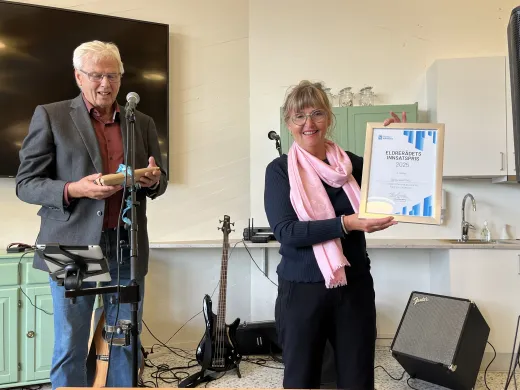 Eldrerådsleder Håvard Sandberg har akkurat gitt eldrerådsprisen til Karmas Klubb. Klubbleder Sissel Ebeltoft med diplomet. Eldrerådsleder sammen med Karmas Klubb-leder. Sistnevnte holder diplom.
