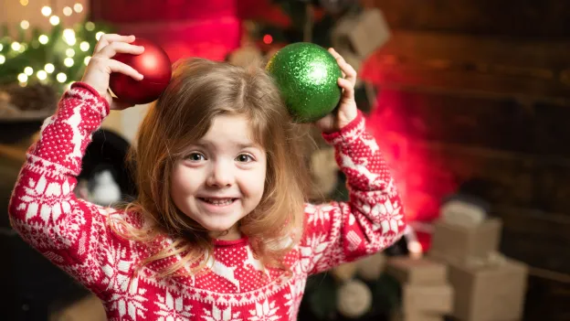 Jente med julegenser og julepynt