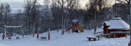 Uteomr&aring;de med lavvo, husker og leket&aring;rn en fin vinterdag med sn&oslash; og bl&aring; himmel