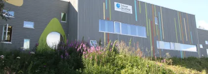 Solneset barnehage sett utenfra en sommerdag med gress og blomster