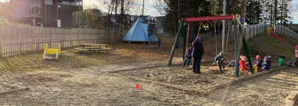 Workinnmarka barnehage uteomr&aring;de med lavvo, husker og mange barn en solrik sommerdag