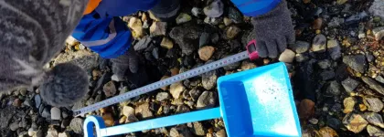 Barn som sitter i fj&aelig;ra og m&aring;ler en bl&aring; spade