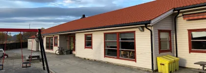 Toftveien barnehage sett utenfra med lekeapparater og sandkasse